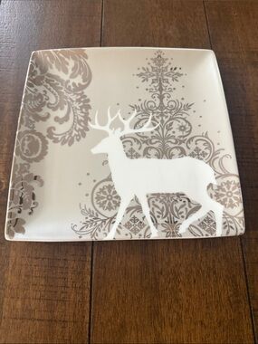 Noble Excellence square salad plate features a white reindeer silhouette surroun